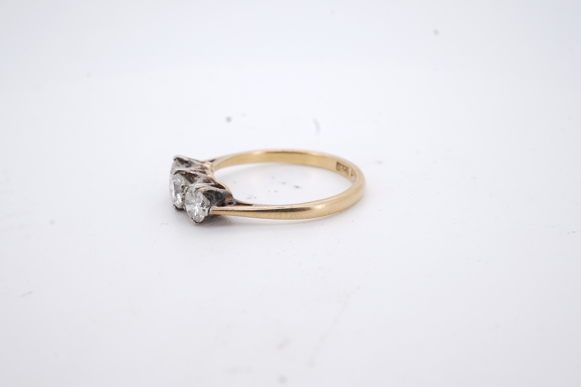 A yellow metal (stamped 18ct, & plat) and three stone diamond set ring, size L, gross weight 2.1 grams.